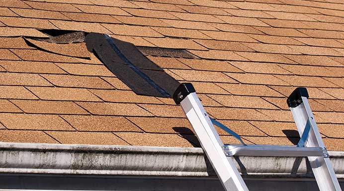 Damaged roof shingles ready for re-roofing